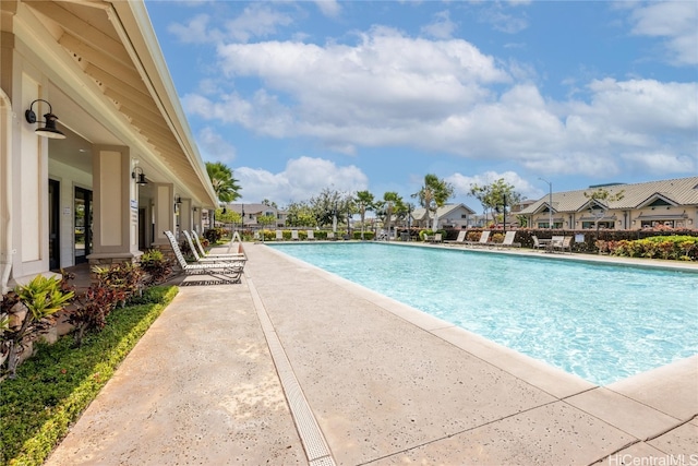 community pool featuring a residential view and a patio