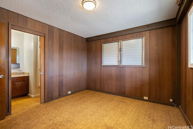94-1377 Hiaai Pl, Waipahu, HI 96797 - unfurnished bedroom featuring a textured ceiling, light floors, baseboards, and wooden walls
