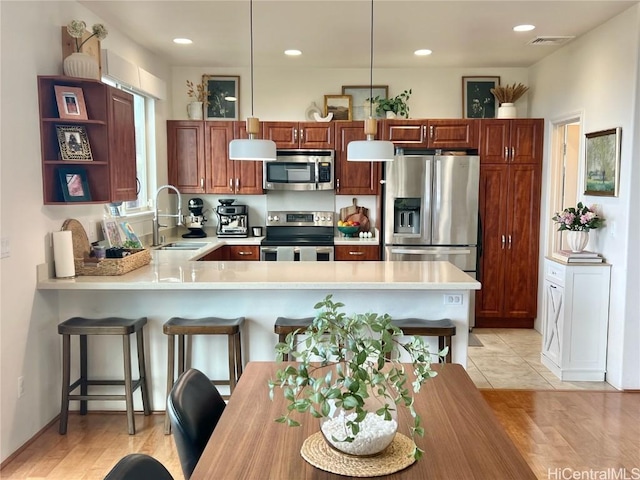 kitchen with light countertops, appliances with stainless steel finishes, a sink, and visible vents