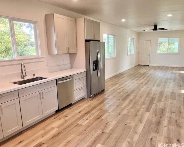 kitchen featuring a wealth of natural light, stainless steel appliances, light wood-type flooring, and a sink