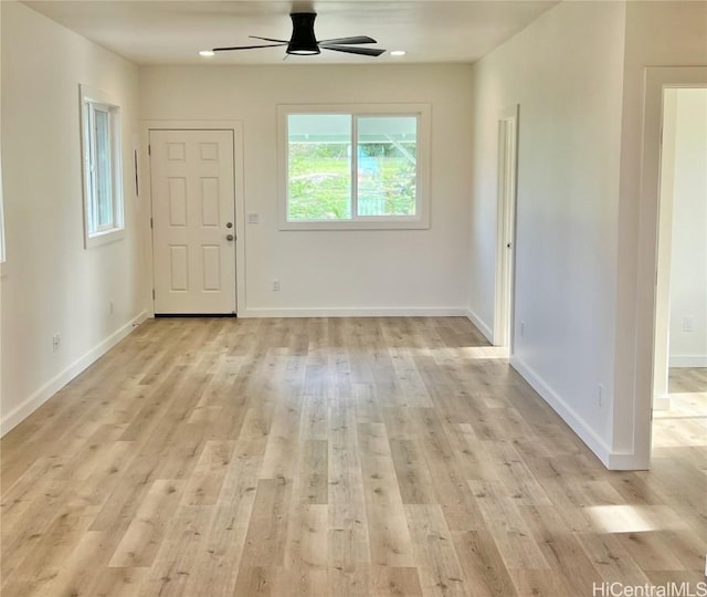 interior space with baseboards, light wood-type flooring, and ceiling fan