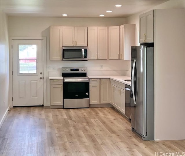 kitchen featuring recessed lighting, stainless steel appliances, light countertops, and light wood-style floors