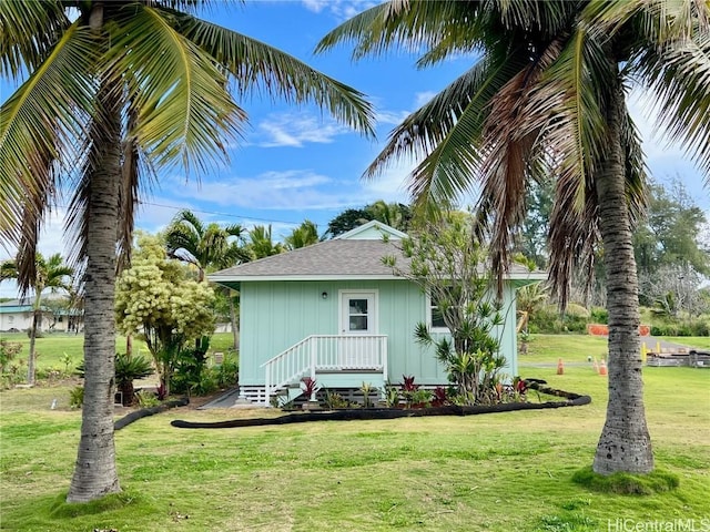 back of house with a lawn and a shingled roof