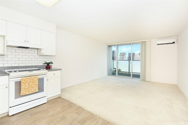 kitchen with under cabinet range hood, white cabinetry, electric stove, light wood-type flooring, and backsplash