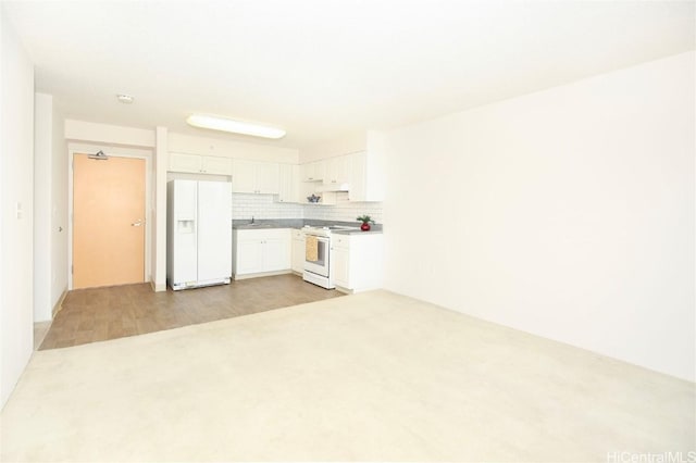 kitchen with white appliances, white cabinetry, light countertops, light wood-type flooring, and tasteful backsplash