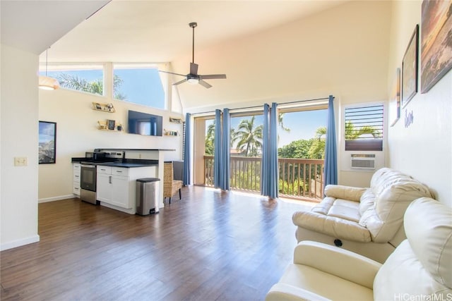 living area with baseboards, a ceiling fan, dark wood-style floors, cooling unit, and high vaulted ceiling