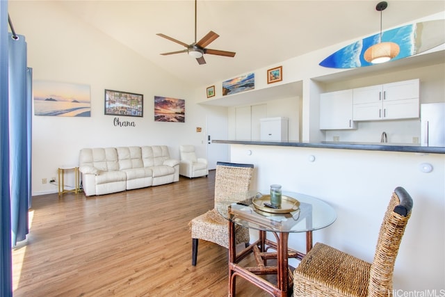 living area featuring light wood-type flooring, ceiling fan, and lofted ceiling