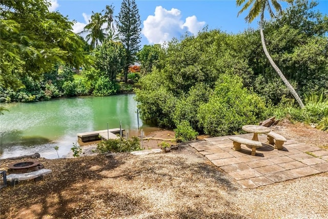 property view of water featuring a boat dock and a fire pit