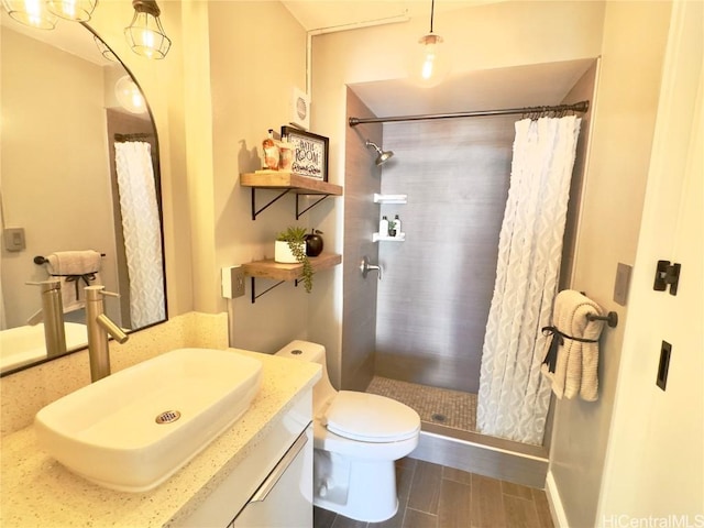 full bathroom with vanity, toilet, and a tile shower