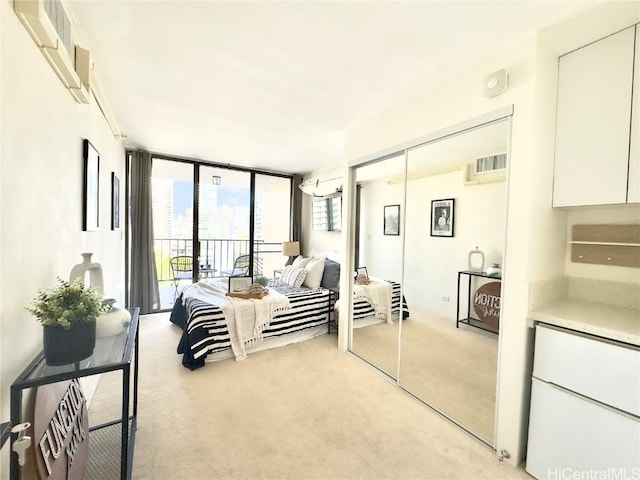 bedroom with access to exterior, expansive windows, a closet, and light carpet