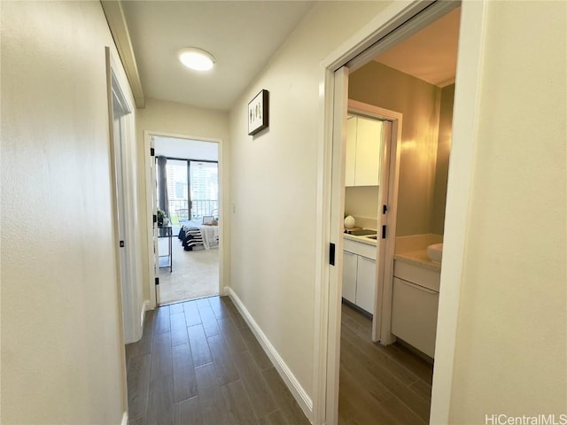 corridor with baseboards and dark wood-style flooring