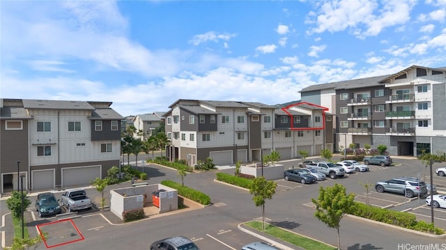 view of property with uncovered parking and a residential view