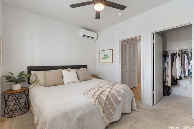 carpeted bedroom featuring ceiling fan, an AC wall unit, a spacious closet, and a closet