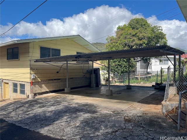 view of vehicle parking with fence and a detached carport