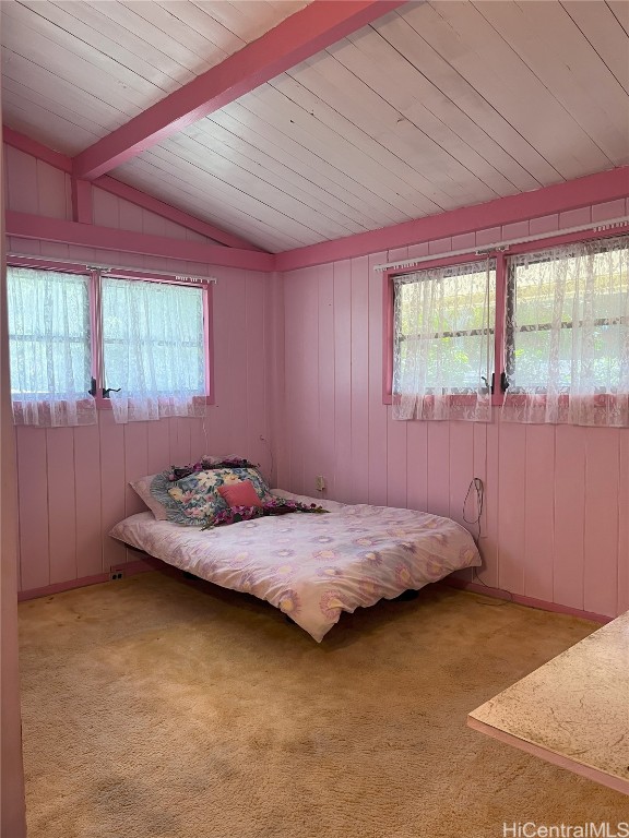 unfurnished bedroom featuring vaulted ceiling with beams and carpet flooring