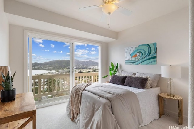 carpeted bedroom featuring ceiling fan and a mountain view