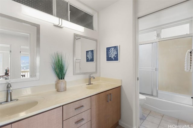 bathroom with toilet, double vanity, a sink, and tile patterned floors