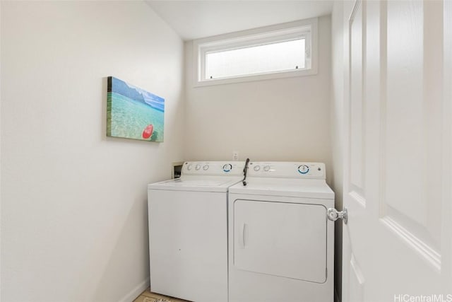 clothes washing area with laundry area, washer and clothes dryer, and baseboards