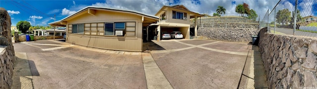 view of front of property featuring concrete driveway and fence