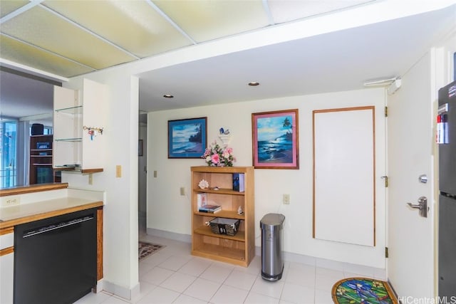 kitchen featuring light tile patterned floors, black appliances, light countertops, and white cabinets