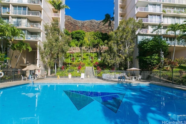 community pool featuring fence and a mountain view