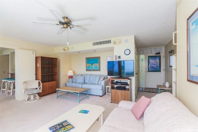 carpeted living room with ceiling fan and visible vents