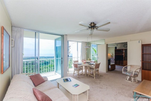 carpeted living area with expansive windows, a ceiling fan, and a textured ceiling