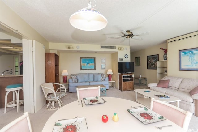 living area featuring a ceiling fan, light colored carpet, and visible vents