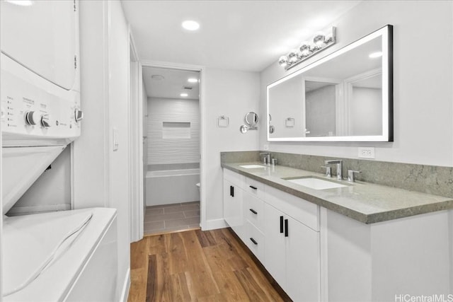 full bathroom with double vanity, a sink, and wood finished floors