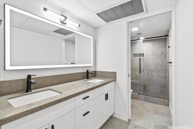 bathroom with double vanity, a stall shower, a sink, and visible vents