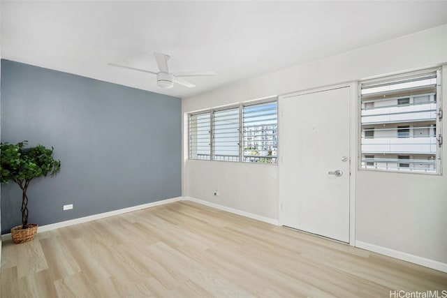 empty room with ceiling fan, baseboards, and wood finished floors