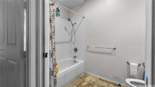 bathroom featuring shower / bath combo with shower curtain, toilet, and baseboards