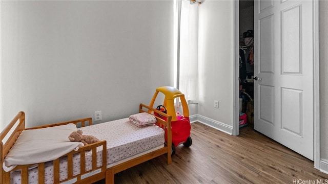 bedroom with wood finished floors and baseboards