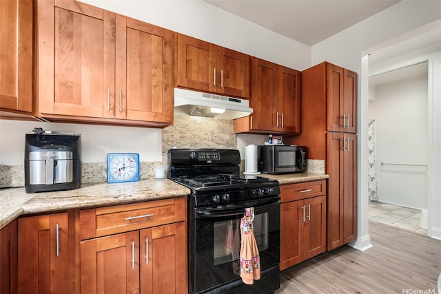 91-1058 Kekuilani Loop Unit 1804, Kapolei, HI 96707 - kitchen with light wood-type flooring, brown cabinetry, black range with gas stovetop, and under cabinet range hood