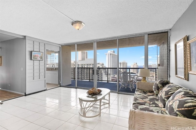 unfurnished living room featuring a wealth of natural light, a textured ceiling, floor to ceiling windows, and a sink