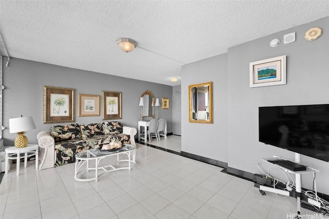 living area featuring baseboards, a textured ceiling, and tile patterned flooring