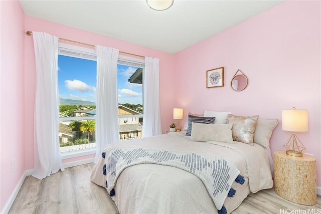 bedroom featuring baseboards and light wood finished floors