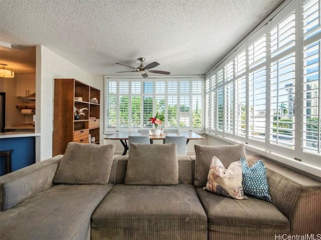 living room with a ceiling fan and a textured ceiling