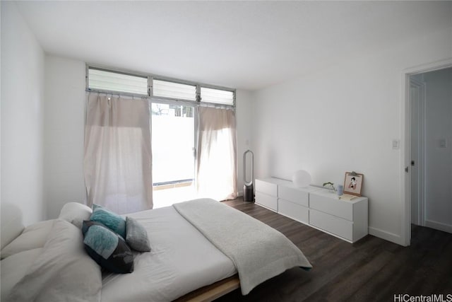 bedroom featuring dark wood-style floors and baseboards