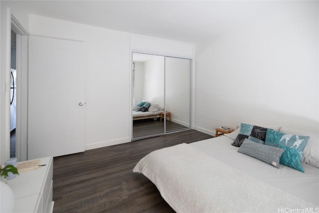 bedroom featuring a closet, baseboards, and wood finished floors