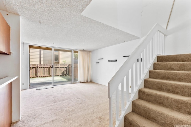 94-414 Kapuahi St Unit 23, Honolulu, HI 96789 - staircase with a textured ceiling, carpet, and expansive windows