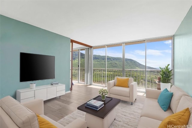 living room with light wood-style flooring, expansive windows, and a mountain view