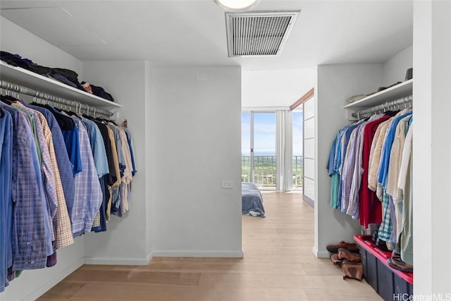 spacious closet featuring visible vents and wood finished floors