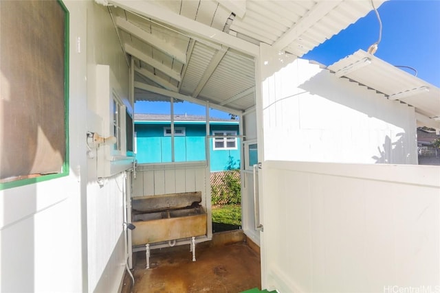 exterior space featuring lofted ceiling and unfinished concrete floors