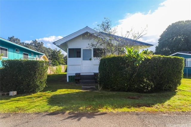 view of front of property with entry steps and a front lawn