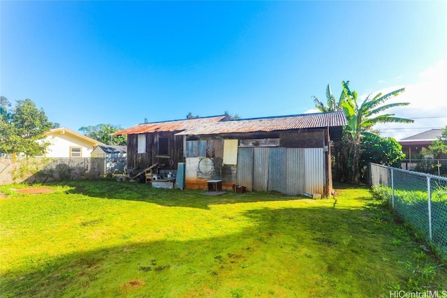 back of property featuring a yard and fence