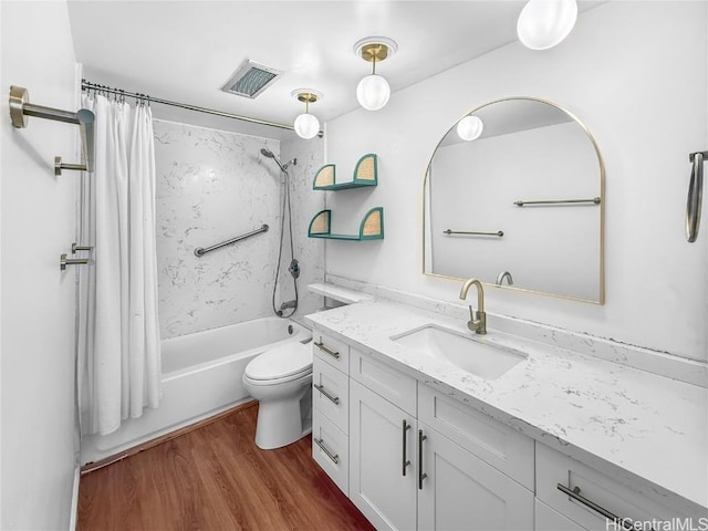 bathroom featuring visible vents, toilet, shower / bath combo with shower curtain, vanity, and wood finished floors