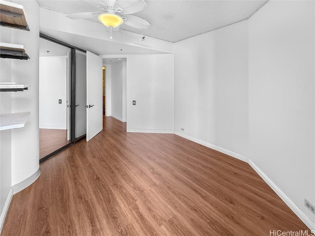 empty room featuring a ceiling fan, baseboards, and wood finished floors