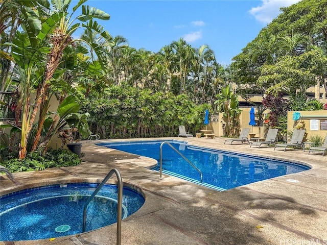 community pool featuring a patio area, a hot tub, and fence