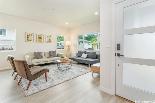 living area featuring baseboards, wood finished floors, and recessed lighting